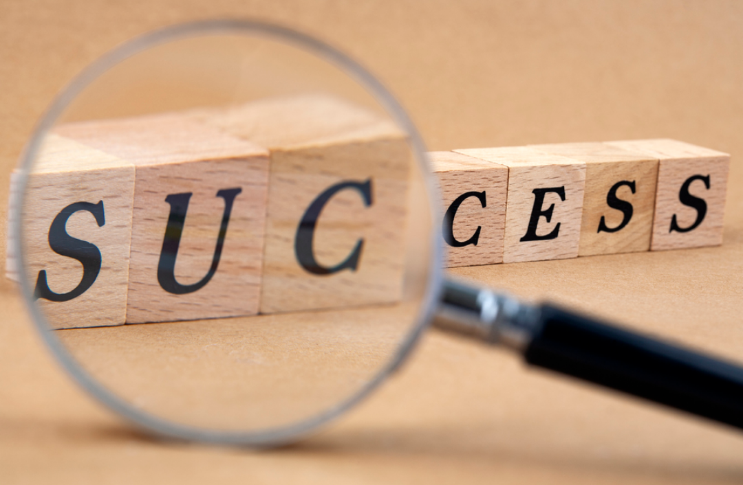 영어로 "성공"이라고 적힌 퍼즐과 돋보기