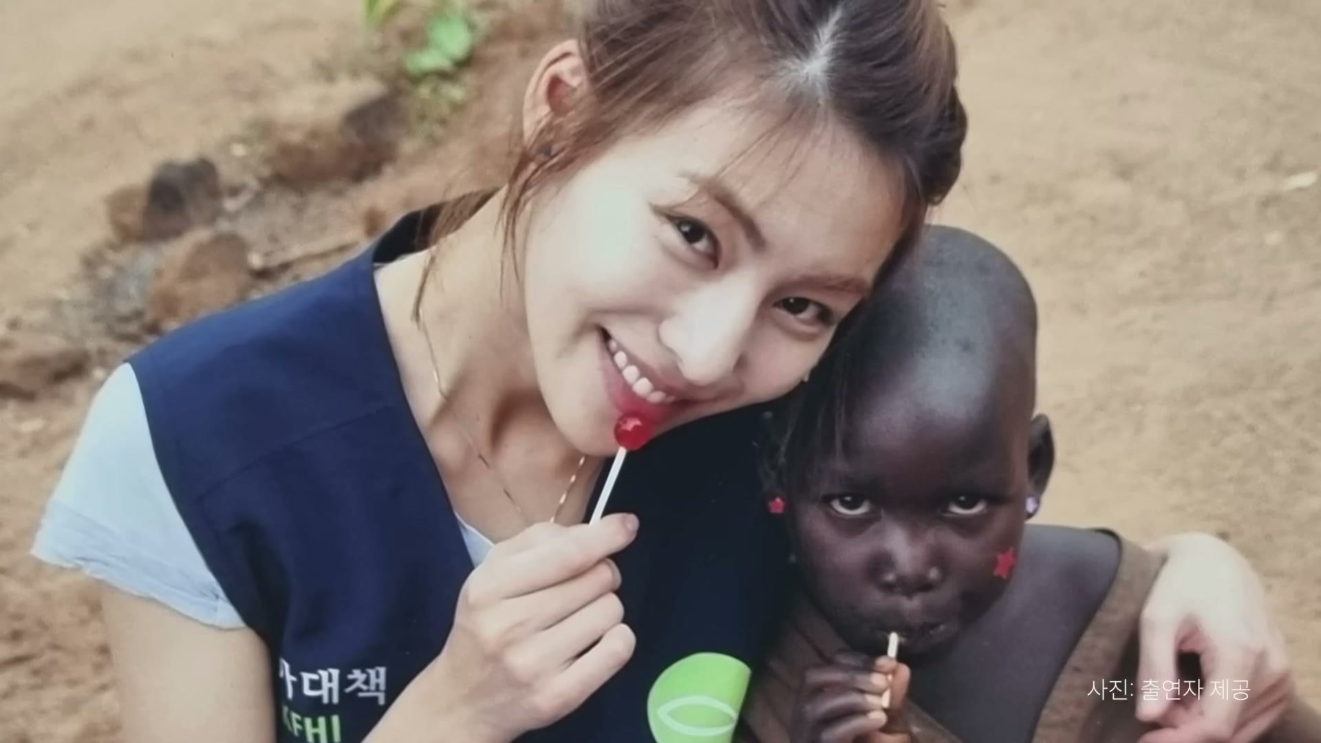 김정화 배우와 어린 아그네스가 우간다 소로티에서 사탕을 함께 먹는 사진
