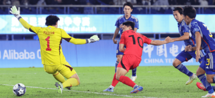 파리-붉은 유니폼을 입은 한국선수가 노란유니폼을 입은 일본 골키퍼를 제치고 골을 넣는 모습