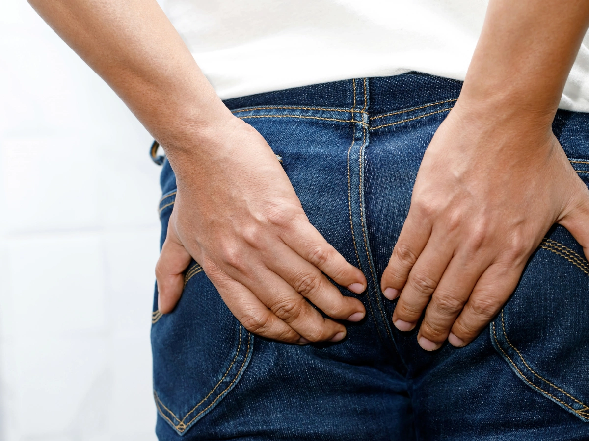 항문 가려움 때문에 엉덩이를 잡고 있는 남자