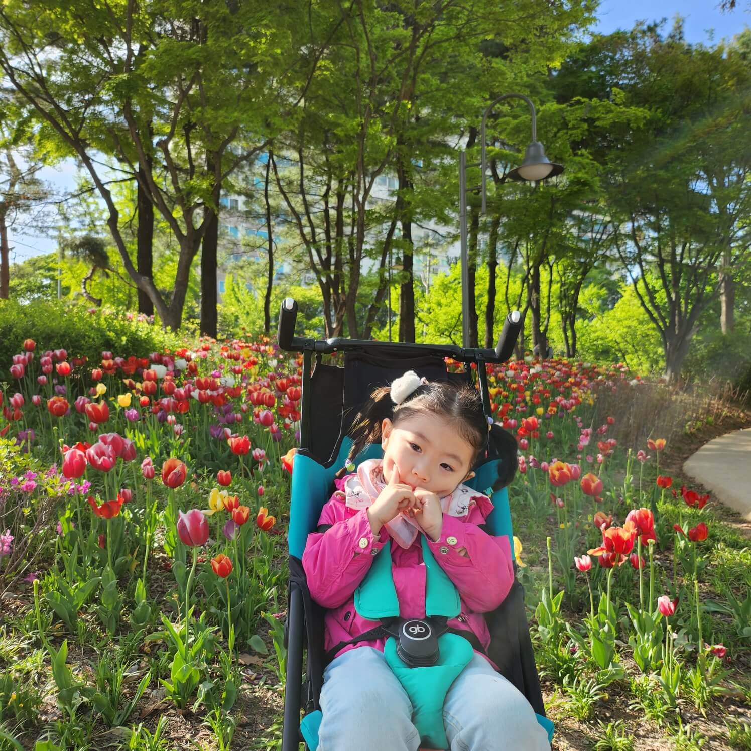 지오비-포킷-플러스-올시티-유모차-추천-공원-꽃밭에서-포즈를-취하는-딸