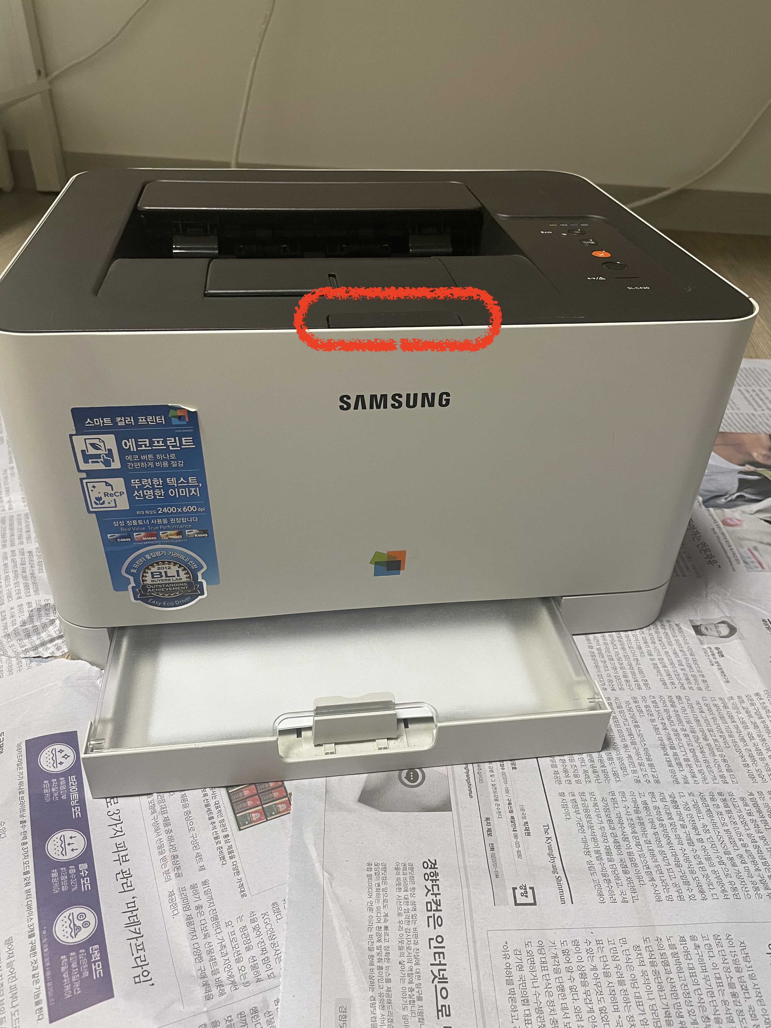 앞 덮개 버튼에 빨간 타원으로 표시된 삼성 프린터 사진