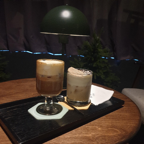 캄캄한 내부. 테이블 위에 컵 두 개가 올려져 있다.