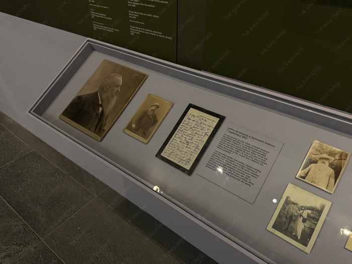 Historical archival display showing Claude Monet handwritten letter from 1912 and black and white portraits.