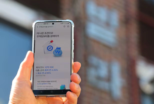 온라인으로 담보대출을 신청하고 있는 핸드폰을 들고 있는 손