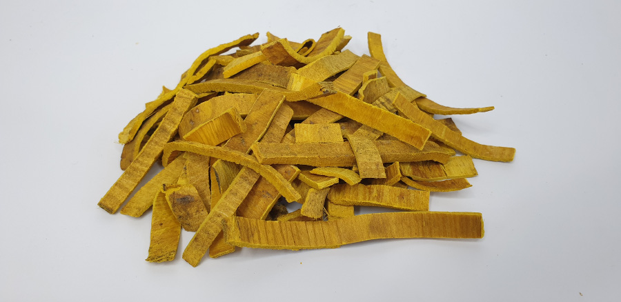 야생에서 채위를 한 황백나무의 껍질인 황백을 깨끗하게 세척하고 손질하고 편으로 썰어놓은 것을 하안 바닥 위에 수북하게 쌓아두고 찍은 사진