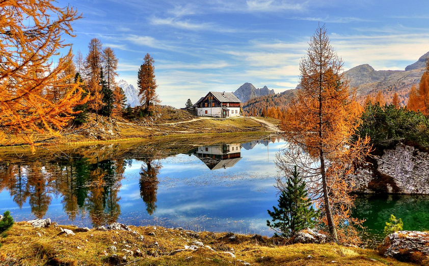 house in autumn foliages and pond