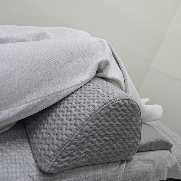 세모꼴의 무릎베개를 안정적으로 사용하고 있는 모습