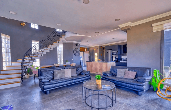 넓은 거실에 파란색 천연가죽 소파가 있다. 왼쪽에는 2층으로 가는 하얀 계단이 곡선으로 설치됐다.