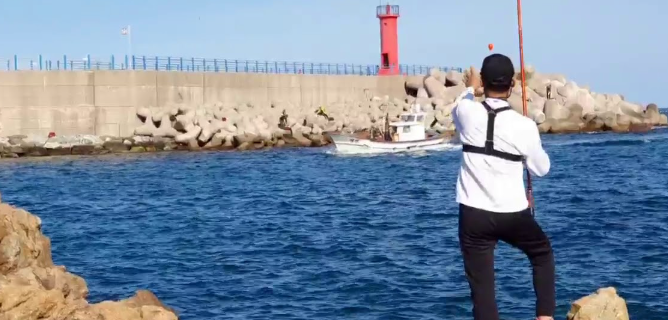 남자 혼자 갯바위에서 낚시하고 있는 모습