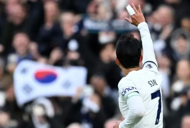 손흥민-
태극기를 든 관객들을 향해 붕대감은 오른손을 들고 유니폼을 입은 손흥민이 손을 흔드는 뒷모습