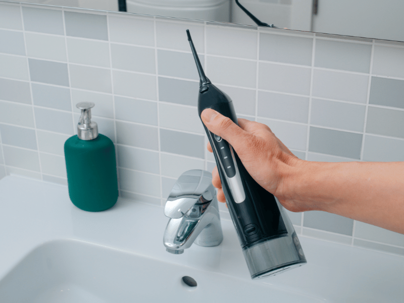 구강세정기를 통해 혀백설과 편도 주변 세균을 세척하는 개념 설명