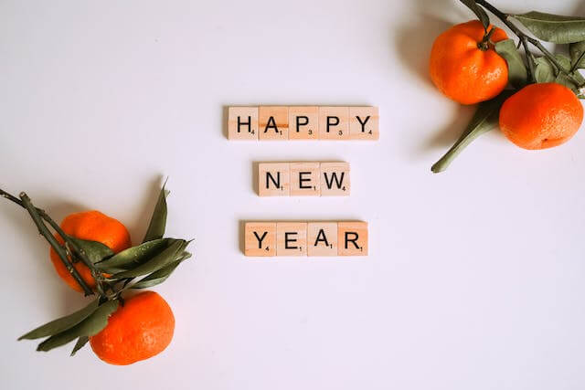 과일과 'HAPPY NEW YEAR'라고 적힌 나무 상자