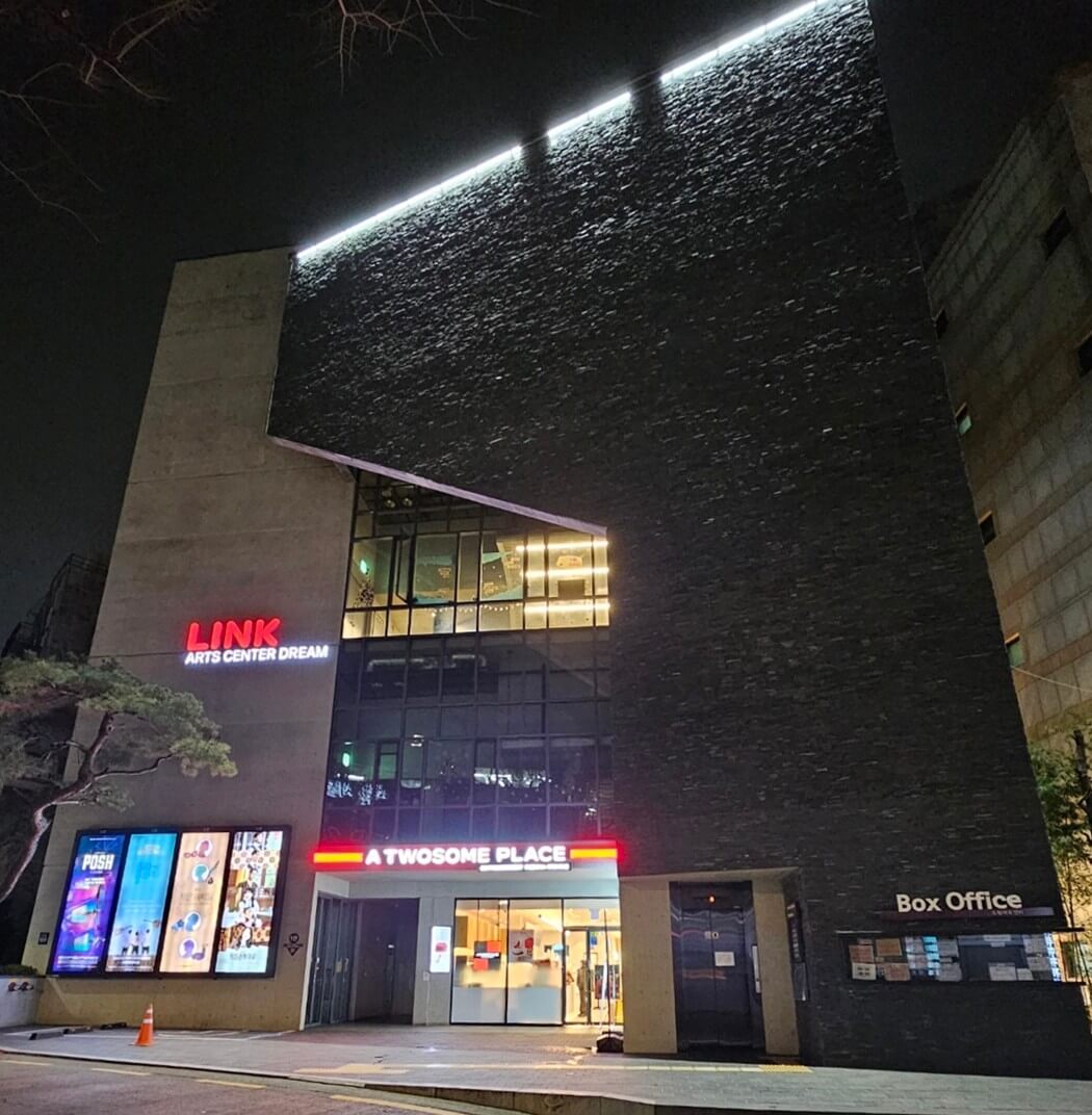 서울 대학로에 위치한 링크아트센터드림 드림1관의 야경. 'LINK ARTS CENTER DREAM' 붉은 간판과 1층 투썸플레이스 카페가 함께 보임.
