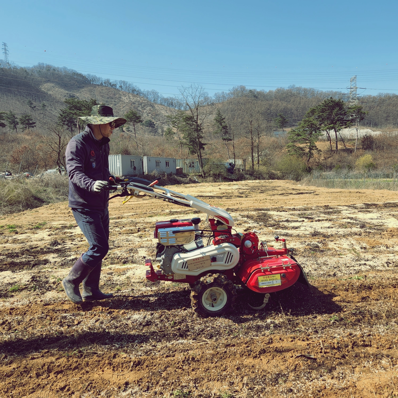 청년 농업인이 관리기로 밭을 로타리 치고 있다