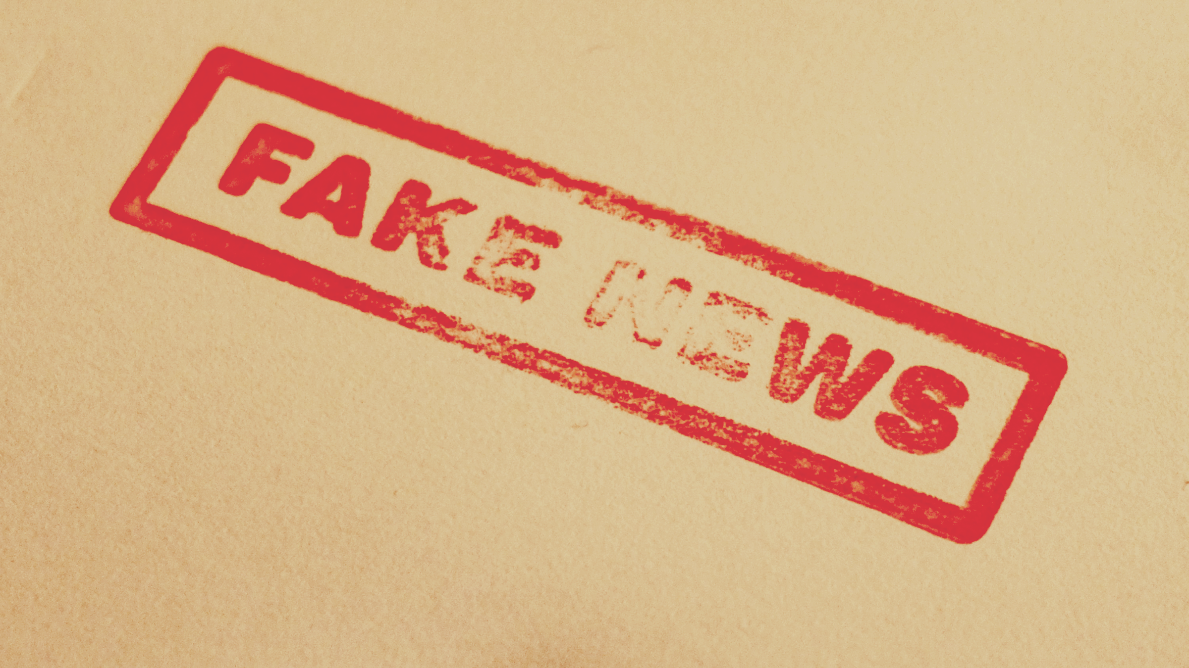 붉은색 직사각형 스탬프로 찍힌 'FAKE NEWS' (가짜 뉴스) 문구. 허위 정보 유포와 사회적 혼란을 상징한다.