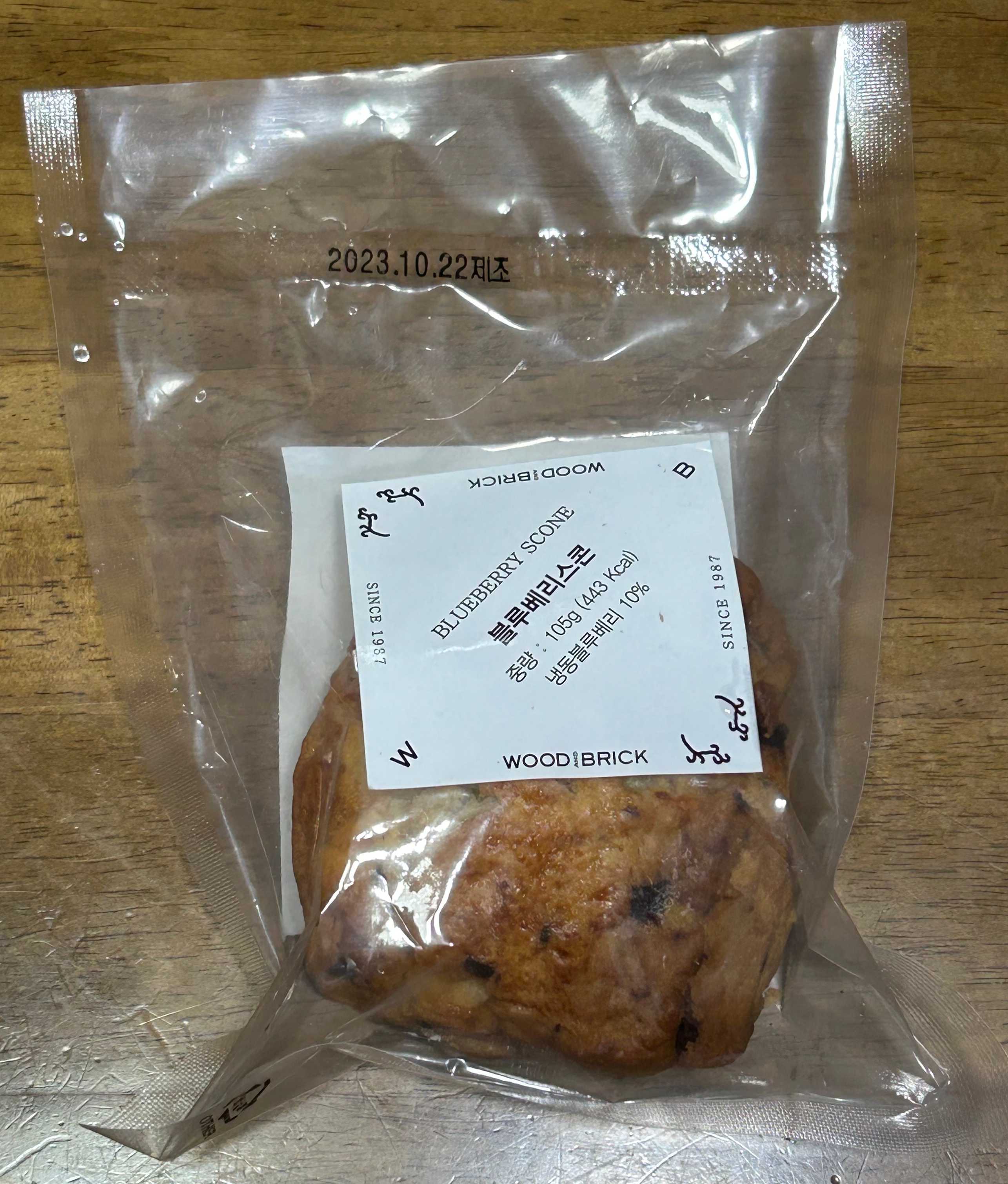 우드앤브릭 블루베리 스콘이 투명 비닐포장지에 담겨있는 모습입니다.