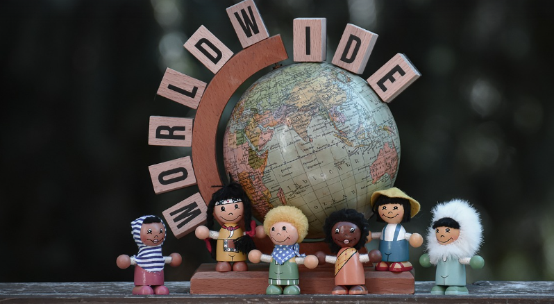 다문화를 상징하기 위한 사진으로 지구본 앞에 여러 인종을 나타내는 인형이 있음