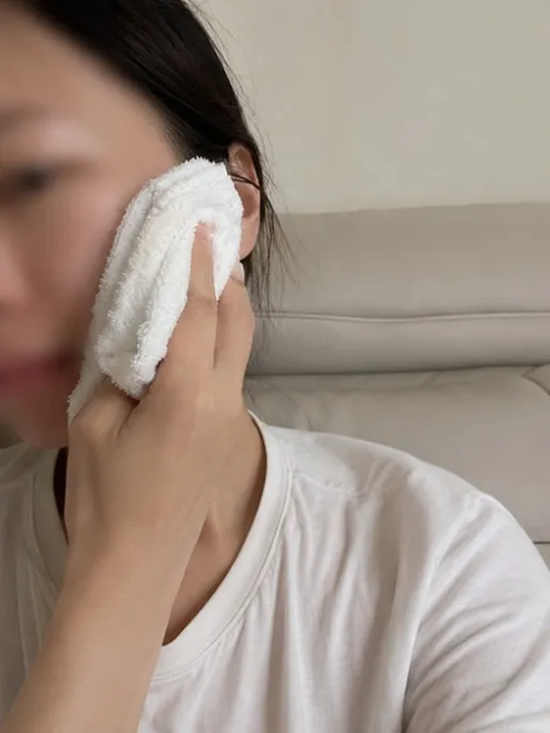 부드러운 타월을 이용해 자극 없이 얼굴 뺨을 닦아내며 세안 후 극심한 건조함과 따가움을 관리하는 40대 여성의 피부장벽 보호 습관