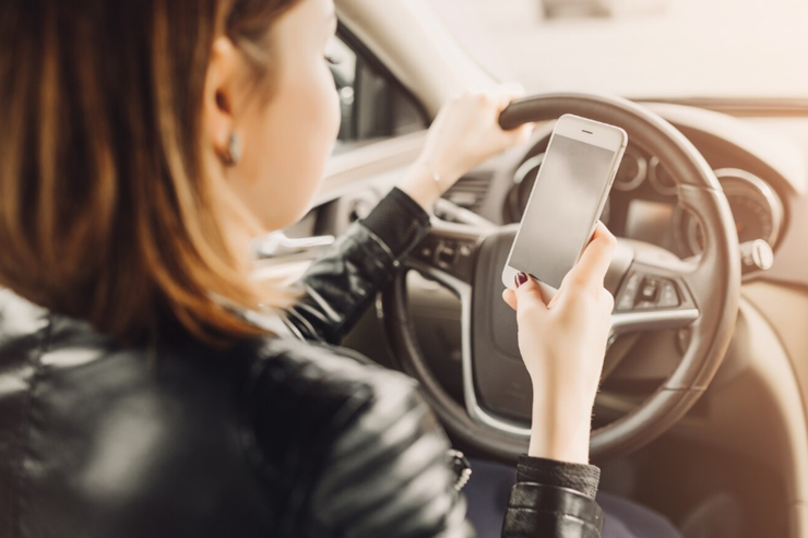 자동차에서 핸드폰을 보는 여자