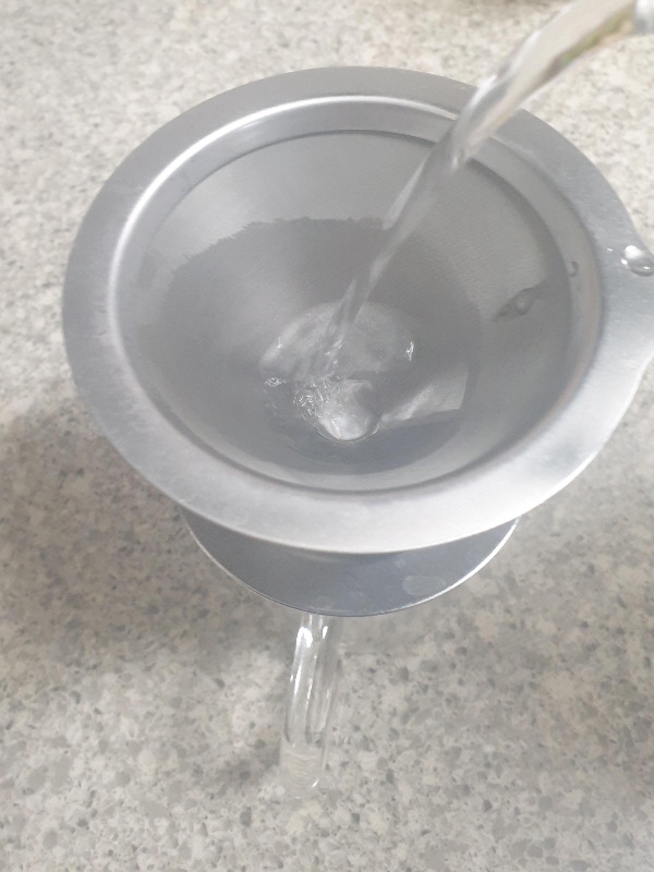 서버 위에 메탈 메쉬 드리퍼가 올려져 있고. 이 드리퍼를 뜨거운 물로 예열 중이다.