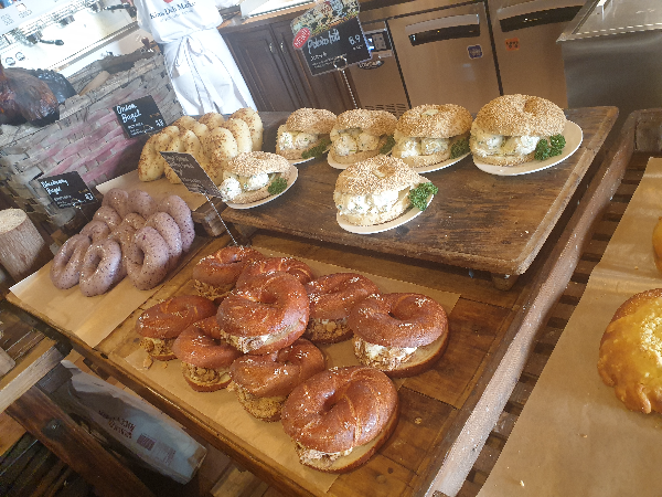 나무 트레이 위에 베이글이 올려져 있다. 속이 가득차 보인다.