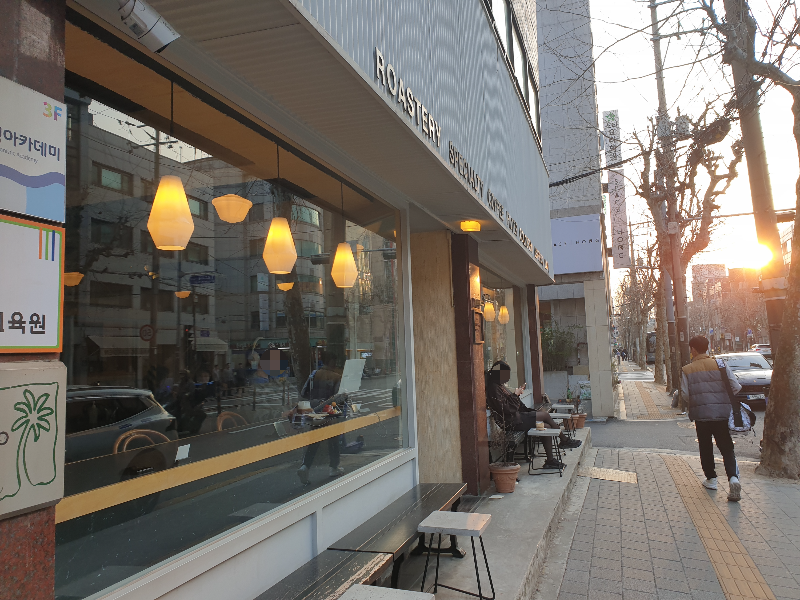 넓은 유리와 야외 벤치가 있는 히트커피 로스터스