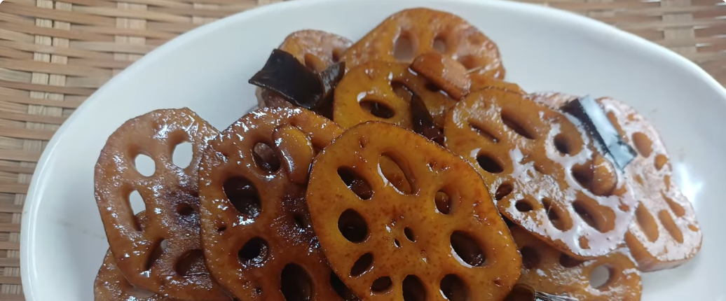 간장 양념에 졸인 연근조림을 흰 접시에 담은 완성 모습