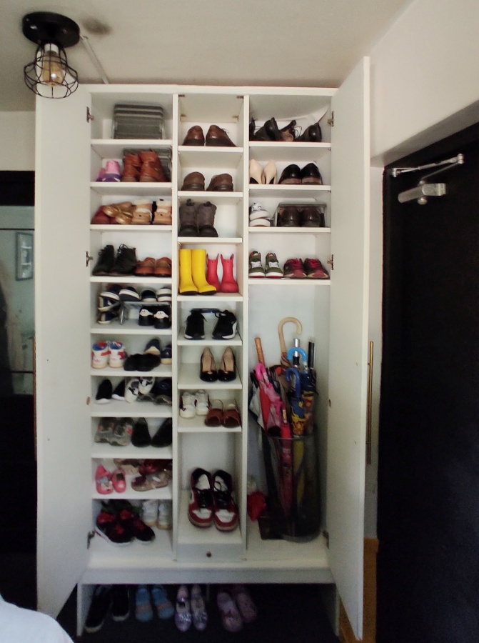 문이 열려 안쪽 많은 신발과 우산이 수납되어있는 사진