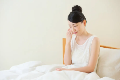 침대에 앉아있는 여성