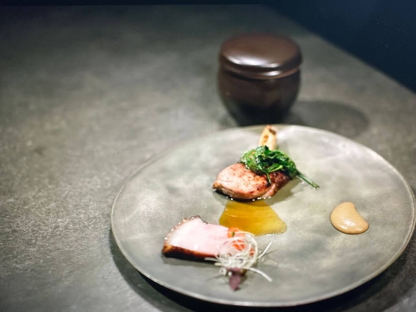 돼지고기 요리와 소스가 회색 접시에 담긴 모습