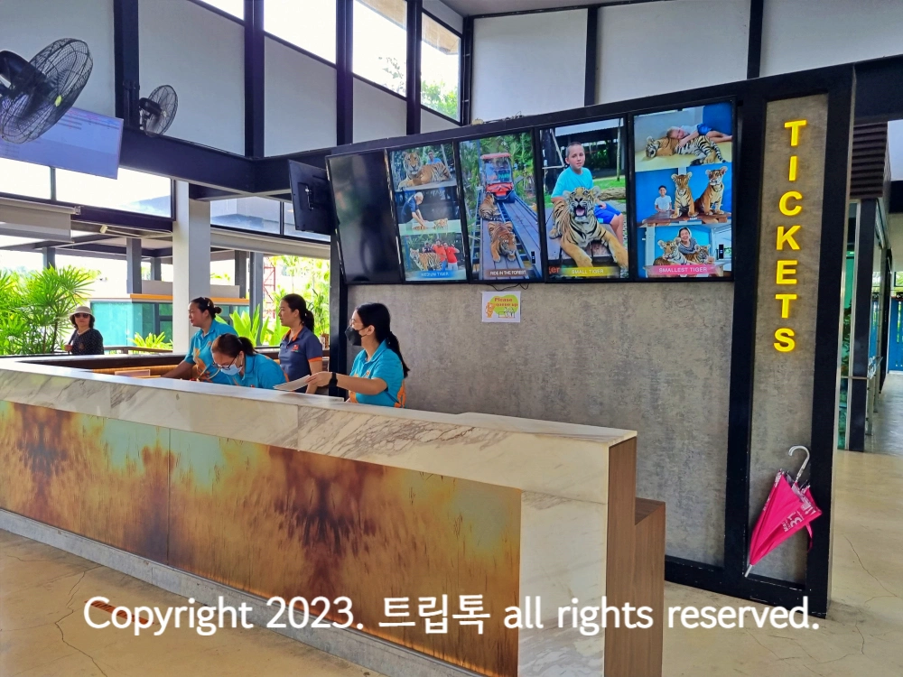 4명의 파란옷을 입은 직원이 손님을 맞이하고있다.