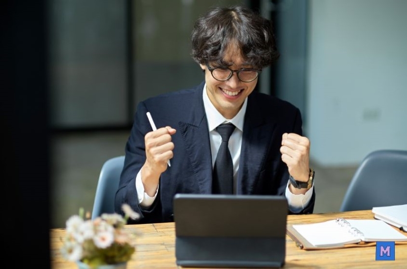 신입직장인이 사무실에서 노트북을 보며 복리후생 혜택을 확인하고 기뻐하는 표정 via canva