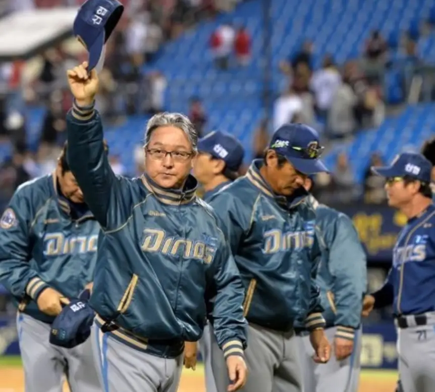 청녹색 야구점퍼를 입고 모자를 든채 걷고있는 김경문 감독