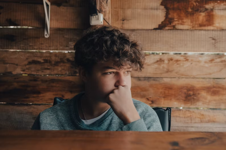 고민하는 표정으로 창밖을 바라보는 청소년 남학생