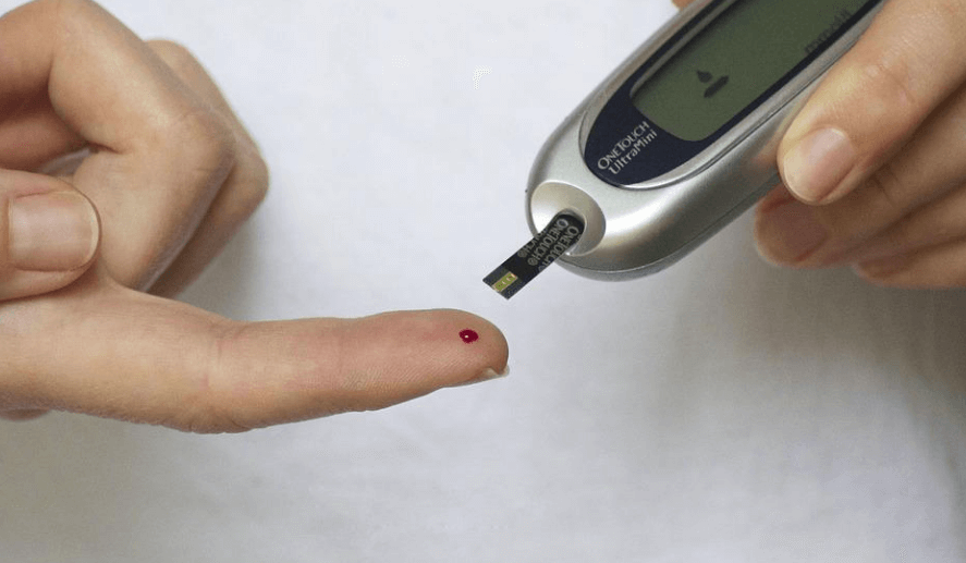 당뇨 검사기를 손가락 끝에 나온 혈액으로 검사를 하고 있다