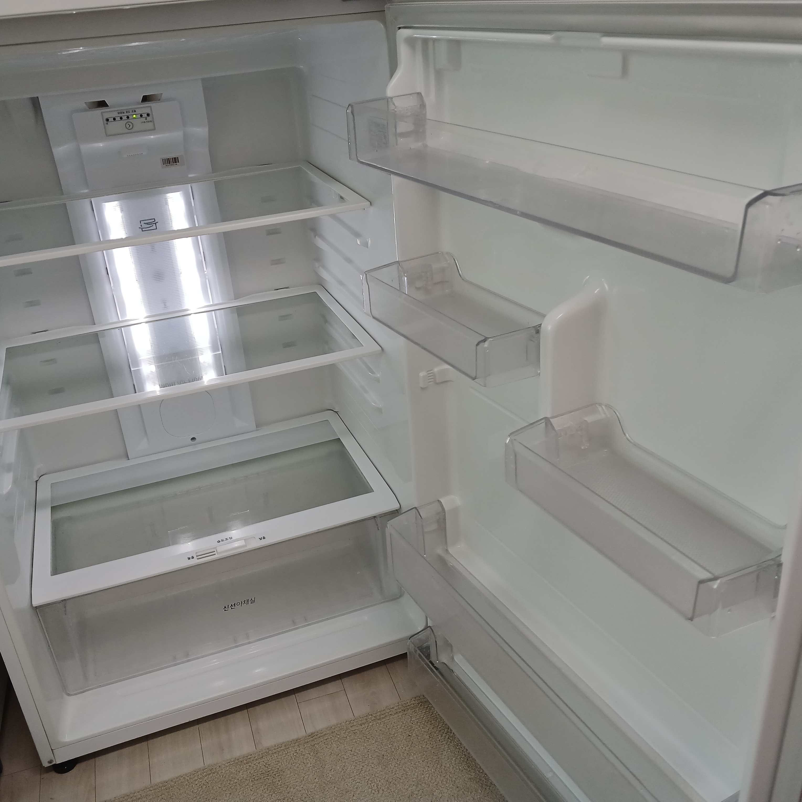 틈새까지 깨끗해진 선반을 다시 끼워 넣어 반짝이는 냉장고 내부와 문 쪽 포켓의 모습