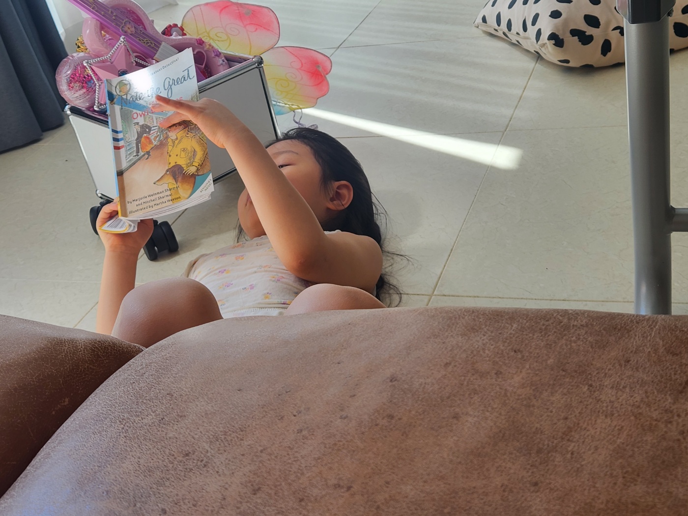 누워서 영어책을 읽는 딸