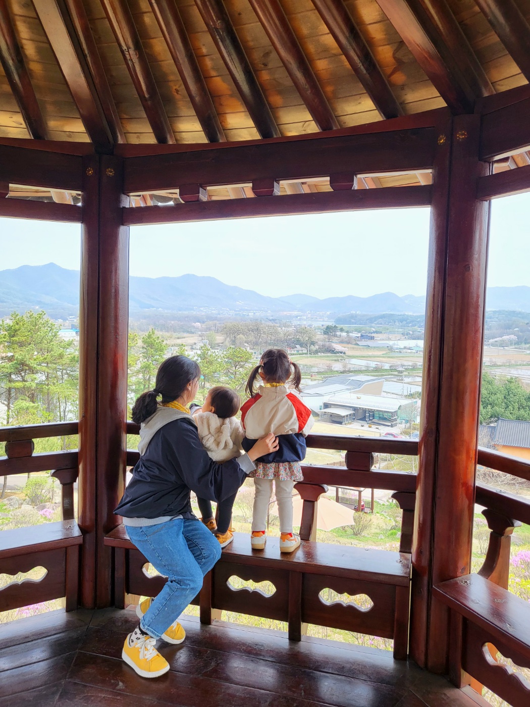 정자에 앉아 풍경을 보는 가족