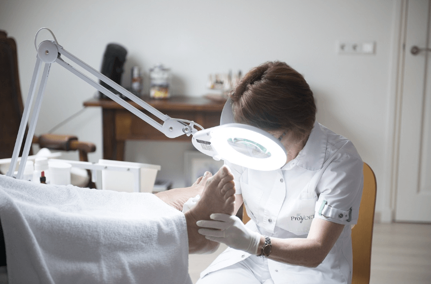 환자의 발을 검사하는 의사