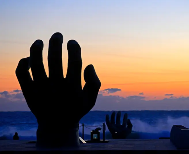 해가 떠오르는 빨간 하늘을 향해 손을 살짝 구루린 동상