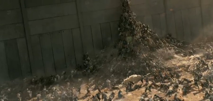 영화의 한 장면. 장벽을 사이에 두고 좀비와 대치 중이었는데 장벽 안에 큰 소리가 일어나 좀비들이 각성하고 장벽을 넘으려고 하고 있다.