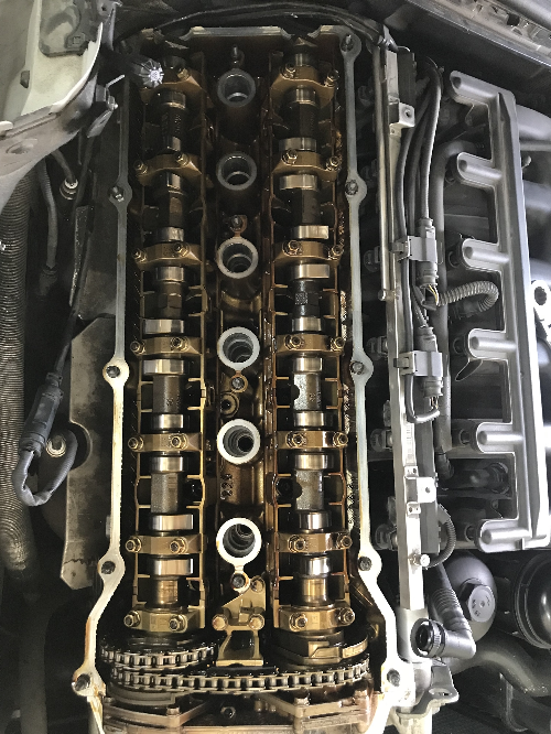 BMW 직렬 6기통 엔진의 유압태핏 교체 전, 실린더 헤드 커버를 탈거한 상태에서 캠샤프트가 노출된 모습