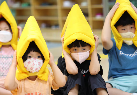 지난 8월 22일 오후 대구 수성구 대구황금유치원에서 을지연습 연계 공습대비 민방위 훈련에서 방재 모자와 마스크를 쓴 어린이들이 대피 훈련에 참여하고 있다.