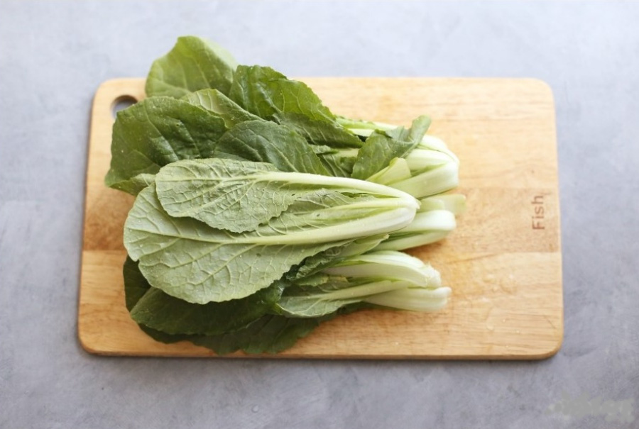 야생에서 채취를 한 배추의 여린 잎인 연배추를 잘 세척한 후에 네모난 나무 도마 위에 수북하게 쌓아놓은 후에 찍은 사진