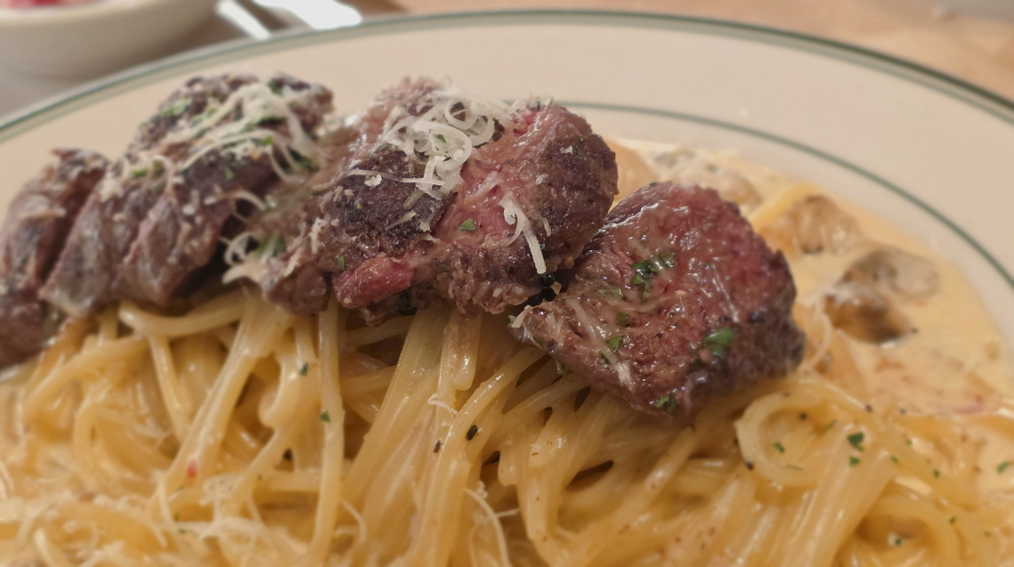 스테이크가 올려진 크림스파게티