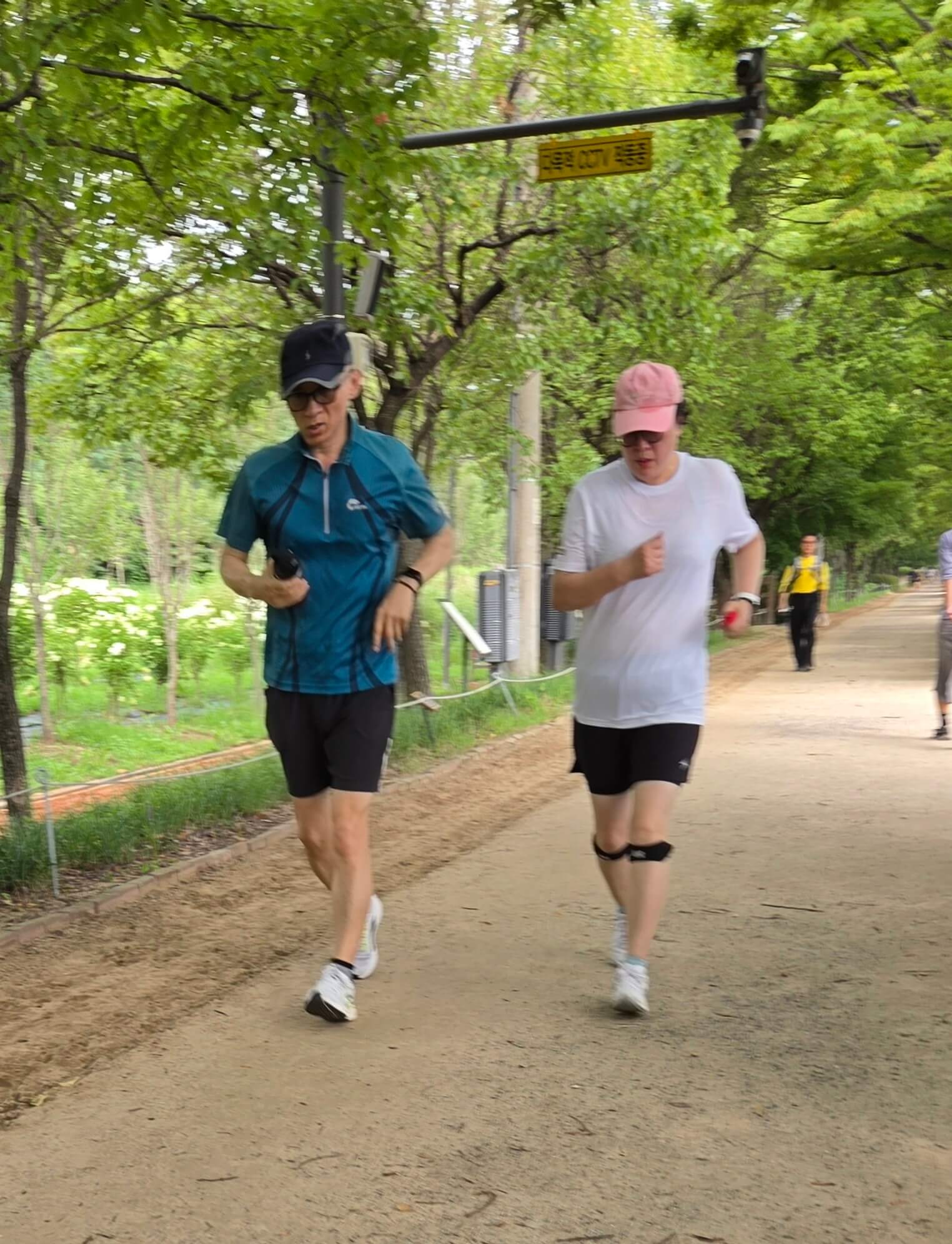 산책로에서 무릎 보호대를 착용하고 함께 달리고 있는 두명의 러너 모습