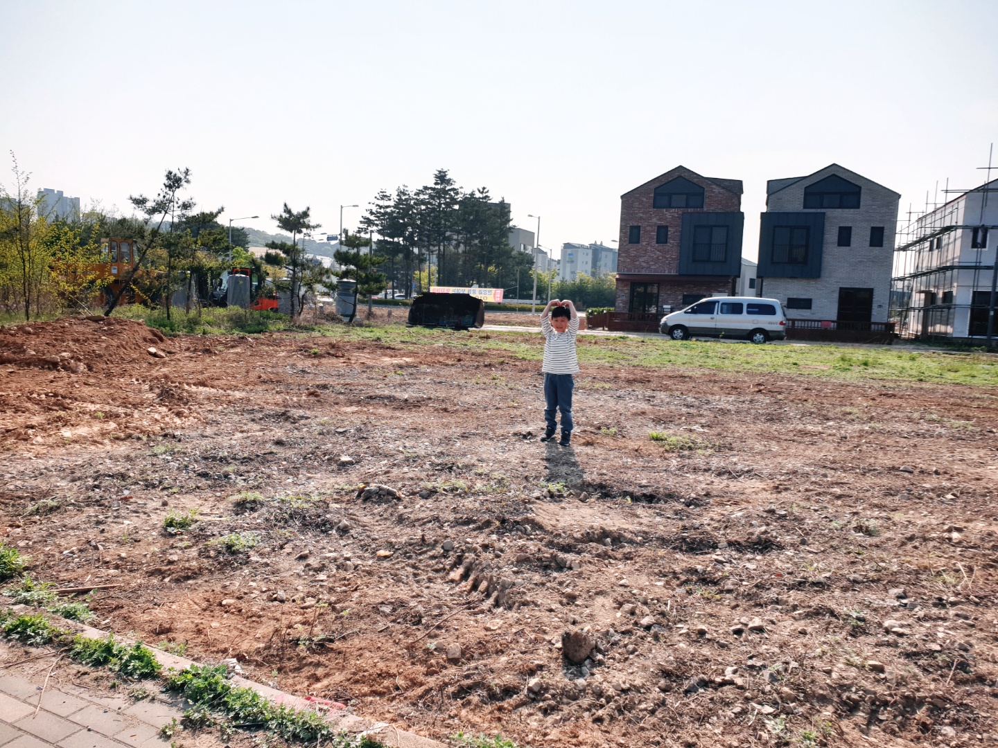 우리가 계약한 택지 위에서 행복한 표정을 짓는 아들의 모습이 담긴 사진