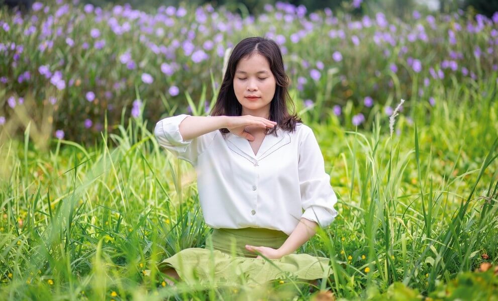 풀 속에서 명상하는 여성