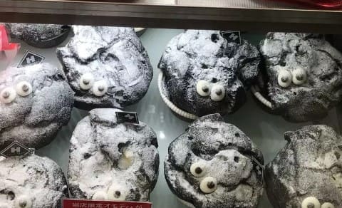 검은 머핀위에 흰색 파우더가 올라가 있다.